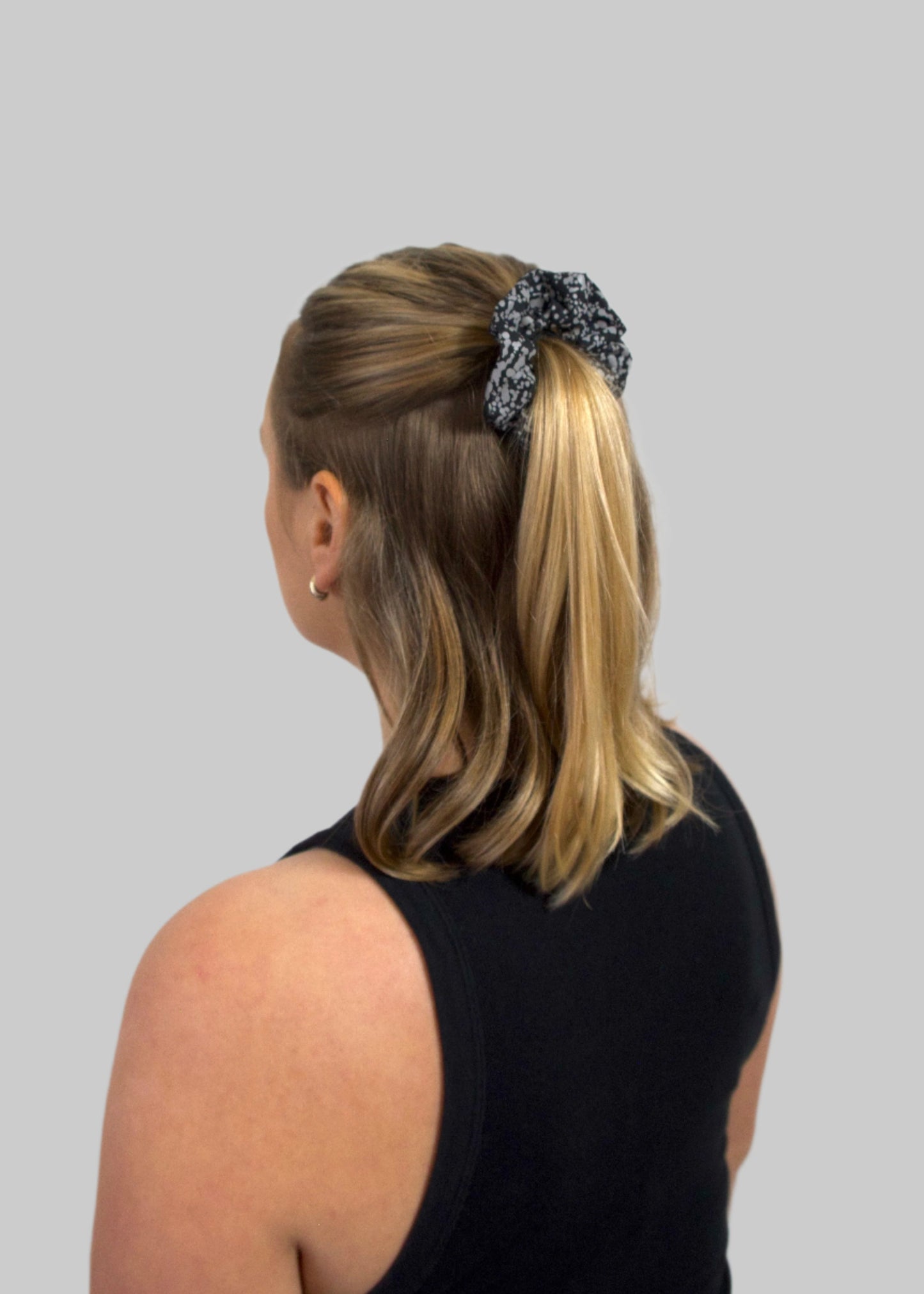 Reflective scrunchie in dotted pattern in hair for added visibility and style, perfect for night walks and outdoor activities